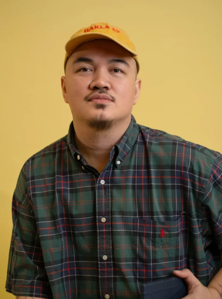 Ryen Paul Sumayao, Director for Memberships and Regional Relations, wearing a cap and plaid shirt