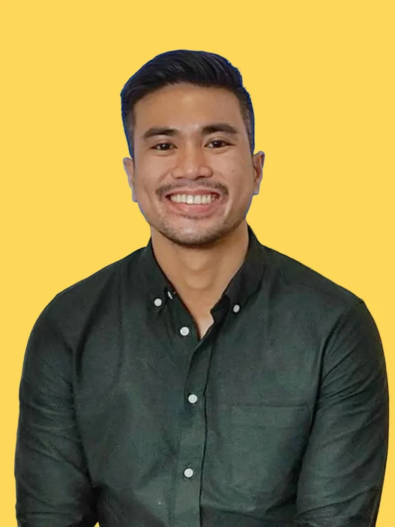Evan Tan, Director for Communications, smiling in a dark green shirt